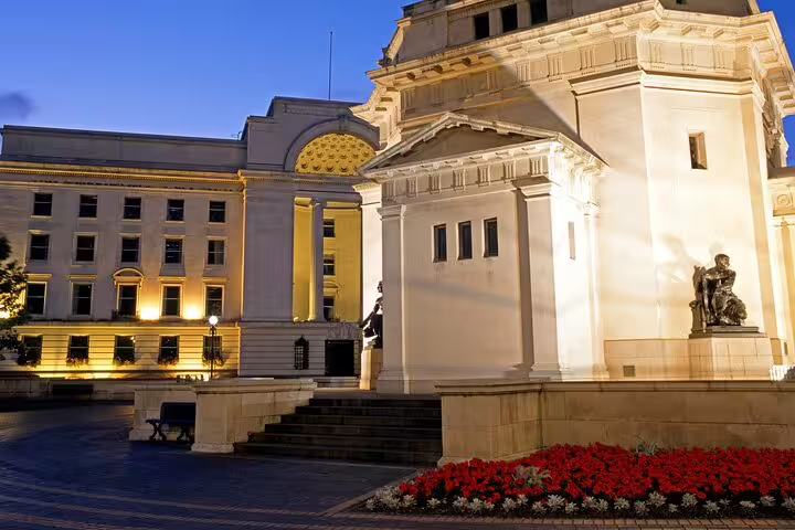 Illuminated neoclassical Birmingham Council House and historic buildings at dusk with red flowers
