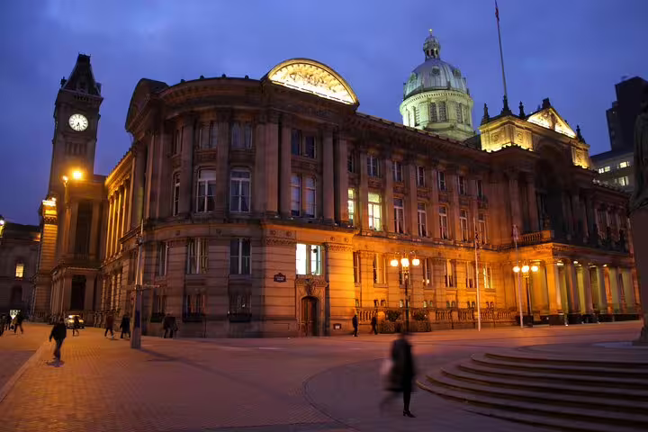 Birmingham Council House and clock tower illuminated at night in Victoria Square