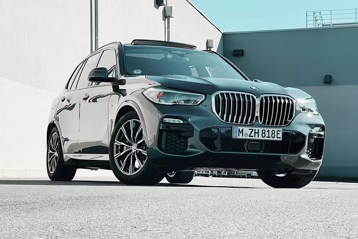 Black BMW X5 SUV luxury transfer vehicle parked outside modern building in Switzerland