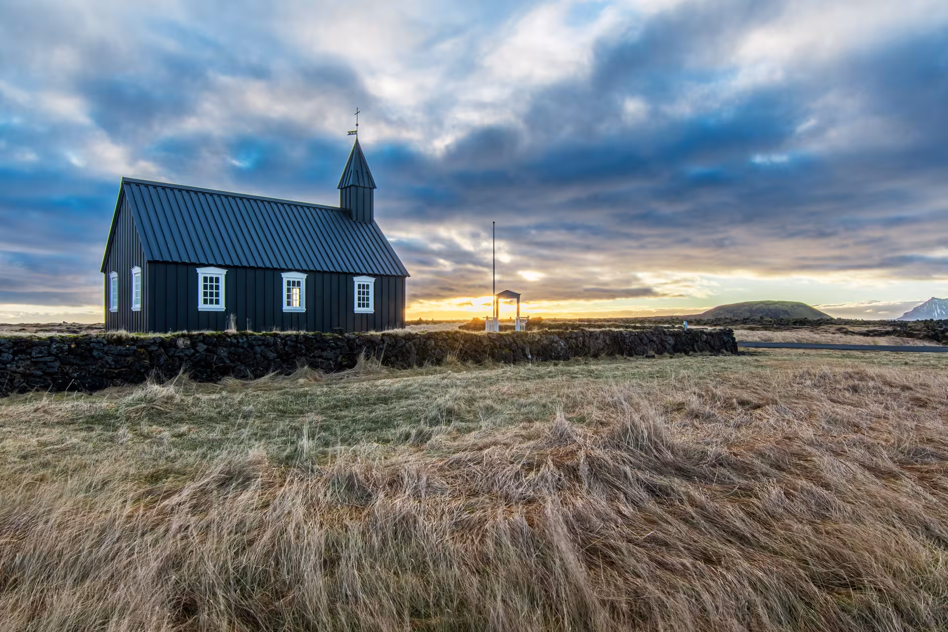Black wooden church at sunset on Snaefellsnes Peninsula Iceland with dramatic cloudy sky
