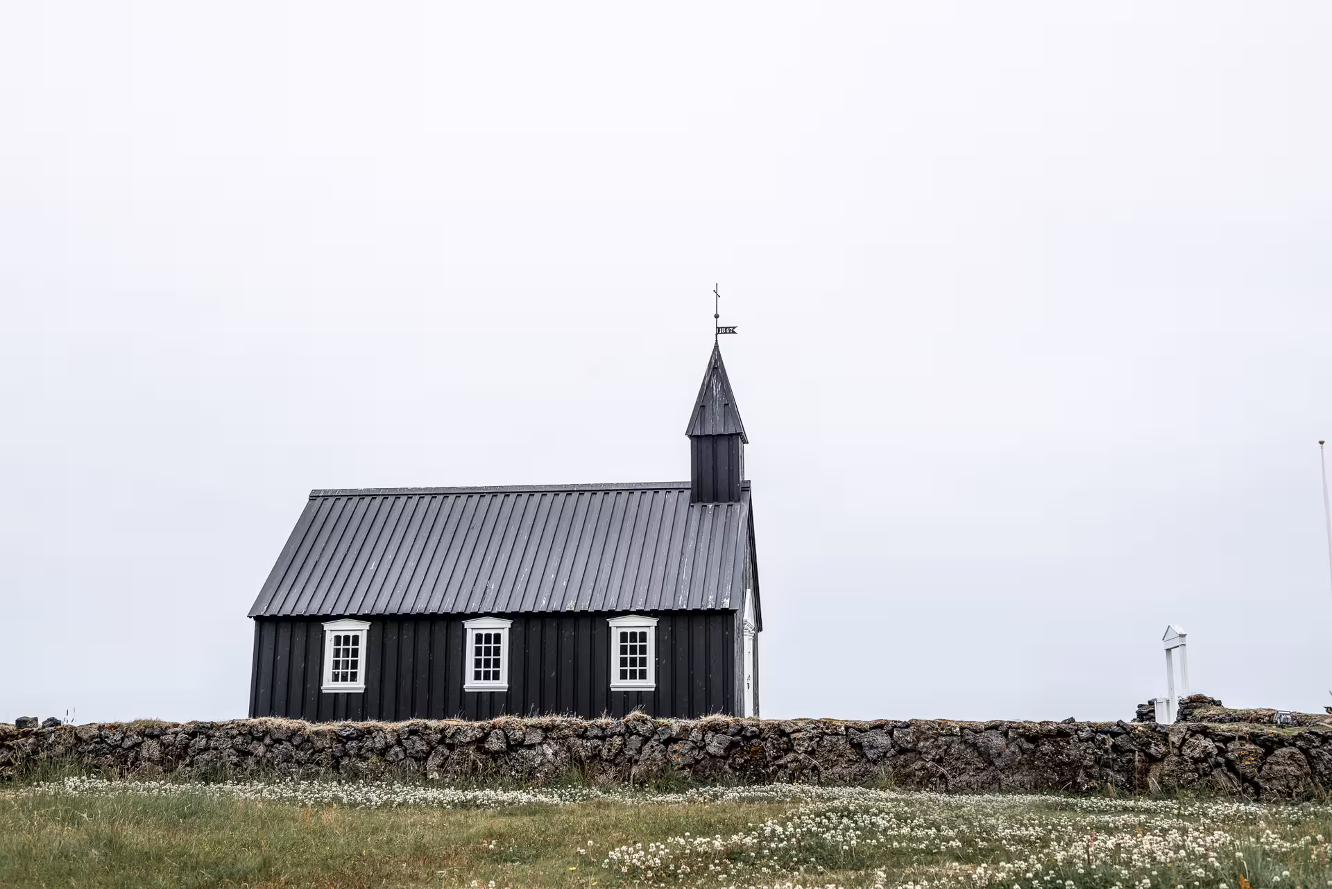 Black wooden church with steeple and white windows on Snaefellsnes Peninsula, Iceland