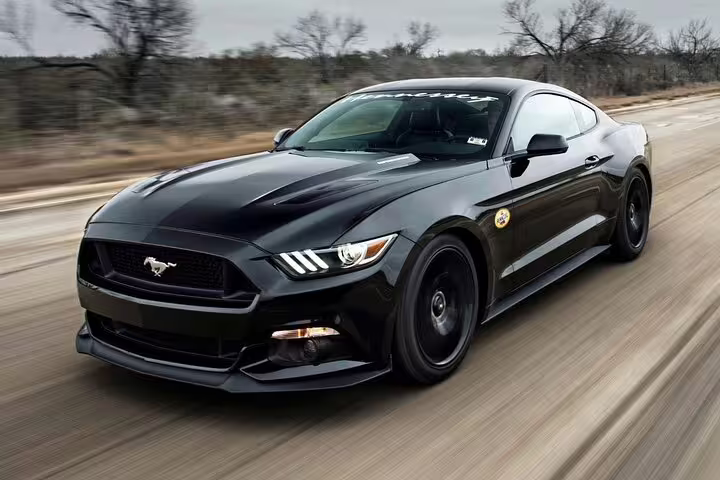 Black Ford Mustang premium sports car driving at high speed on open road