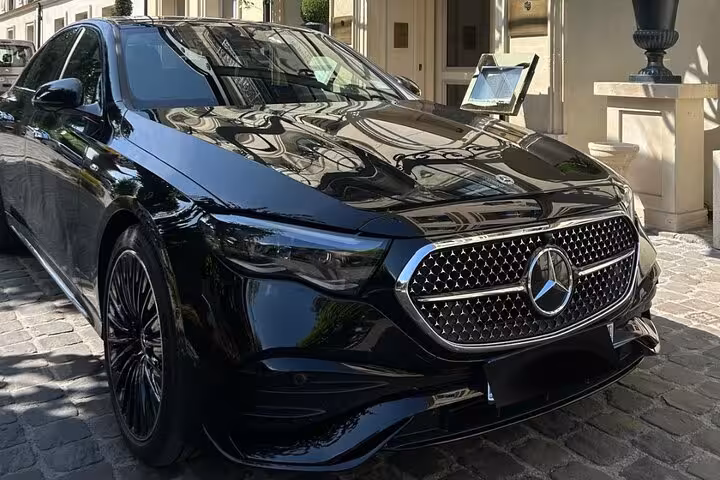 Black Mercedes-Benz luxury sedan parked outside elegant building for private transfer service