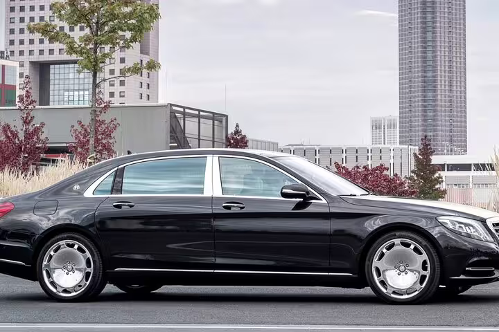 Black Mercedes-Maybach luxury sedan parked in urban setting for private chauffeur transfer service
