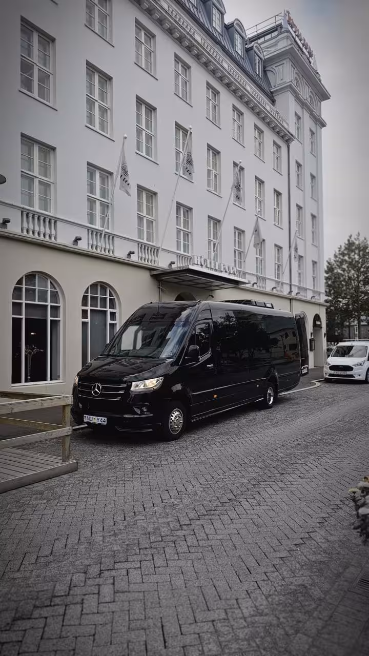 Black Mercedes Sprinter luxury van parked outside Hotel Borg in Reykjavik for private transfer service