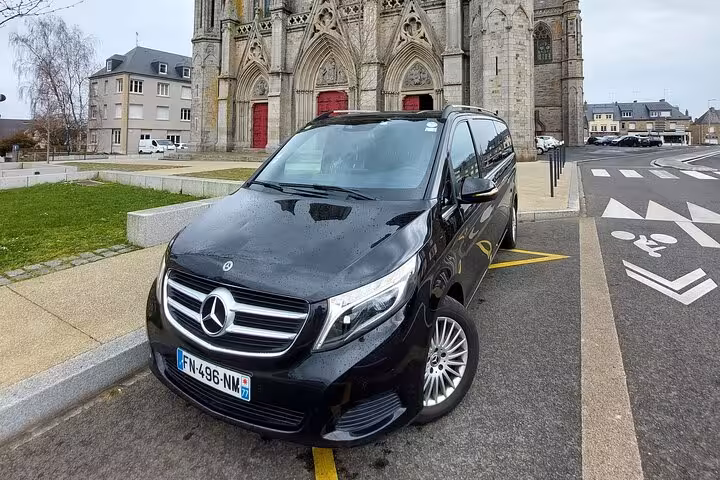 Black Mercedes-Benz V-Class van parked in front of a Gothic church in France