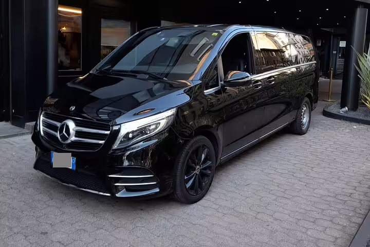 Black Mercedes-Benz V-Class luxury van parked outside hotel for private airport transfer