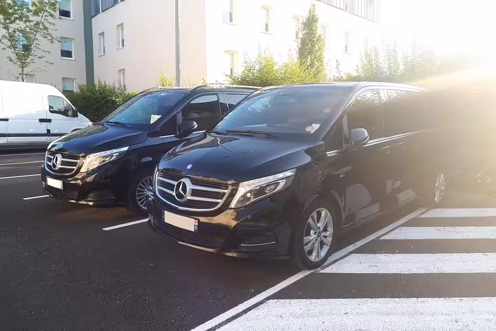 Two black Mercedes-Benz V-Class vans parked for private airport transfer service in Paris