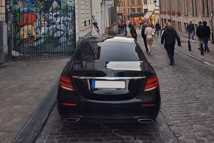 Black Mercedes-Benz sedan on cobblestone street in Paris for private airport transfer