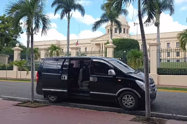 Black private transfer minivan parked near a landmark building for Mecca to Jeddah Airport JED departure service