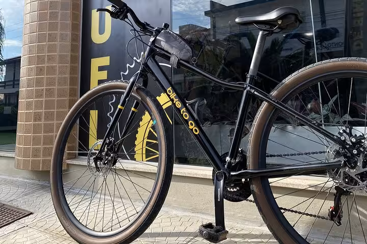 Close-up of a black mountain bike parked outside a shop, perfect for exploring Florianopolis on a guided tour.