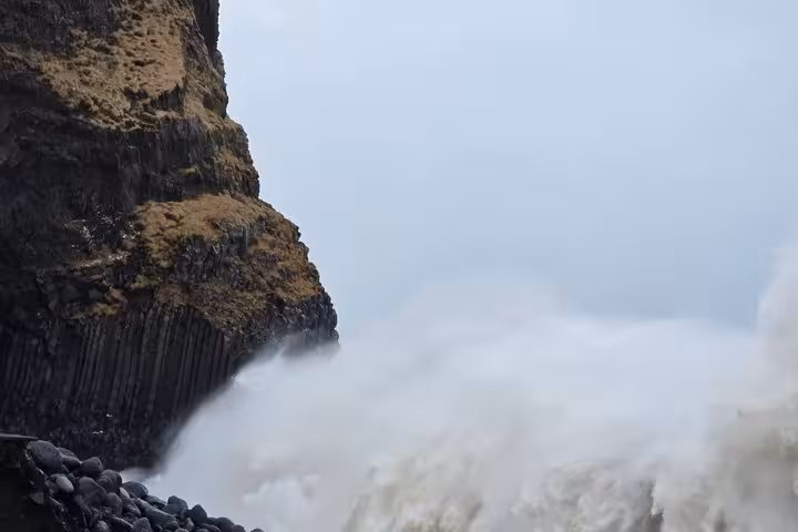 Massive waves crashing against black basalt column cliffs at Reynisfjara black sand beach, Iceland