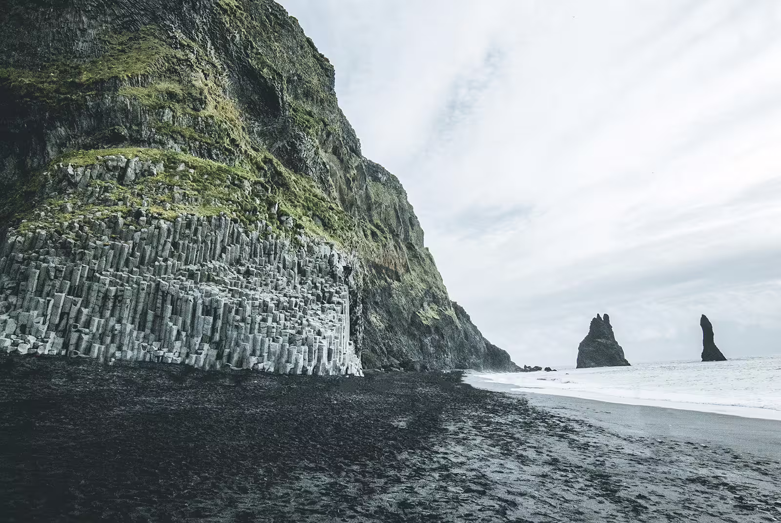Black sand beach with basalt columns and Reynisdrangar sea stacks on Iceland's south coast