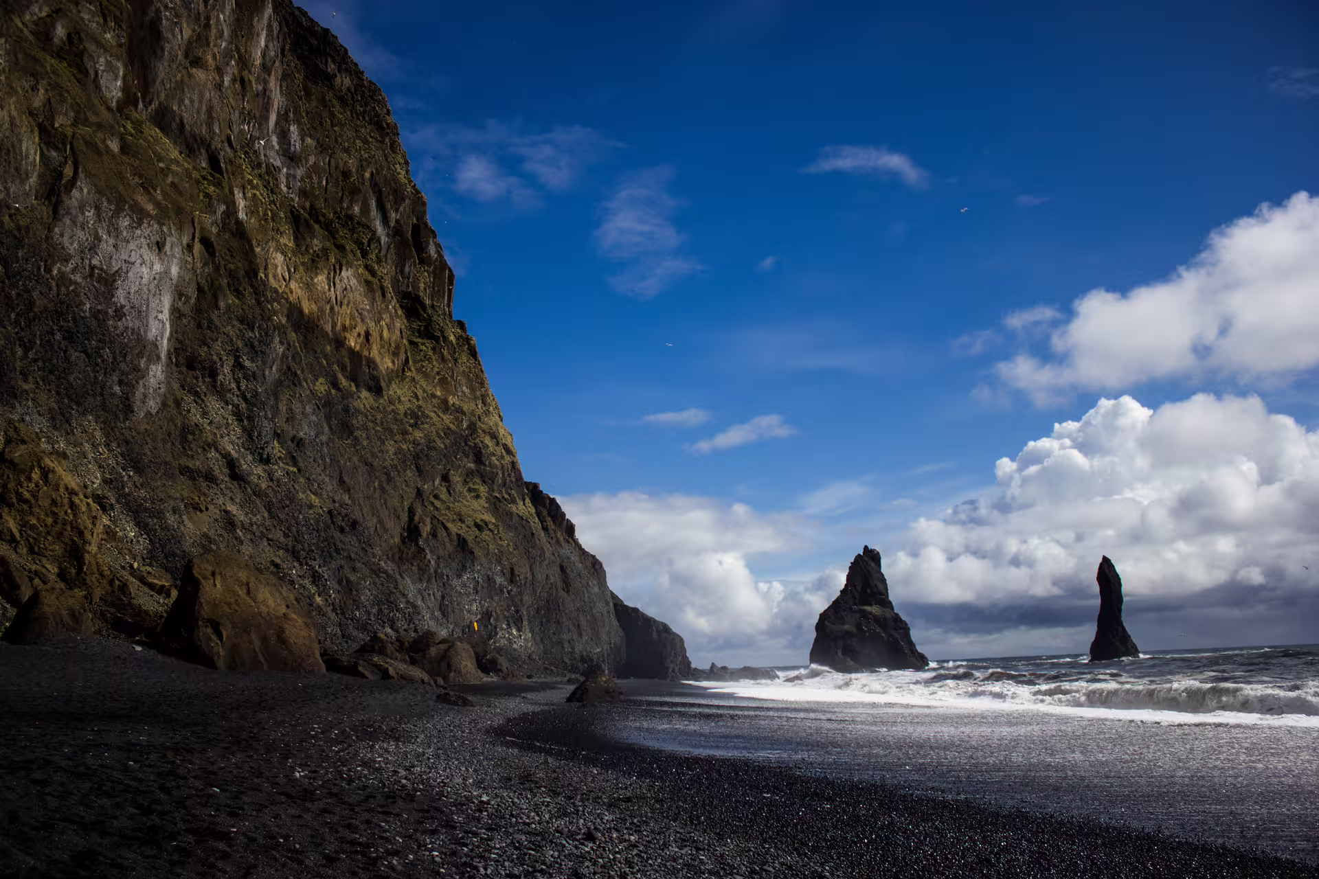Black sand beach with dramatic basalt sea stacks and cliffs along Iceland's South Coast
