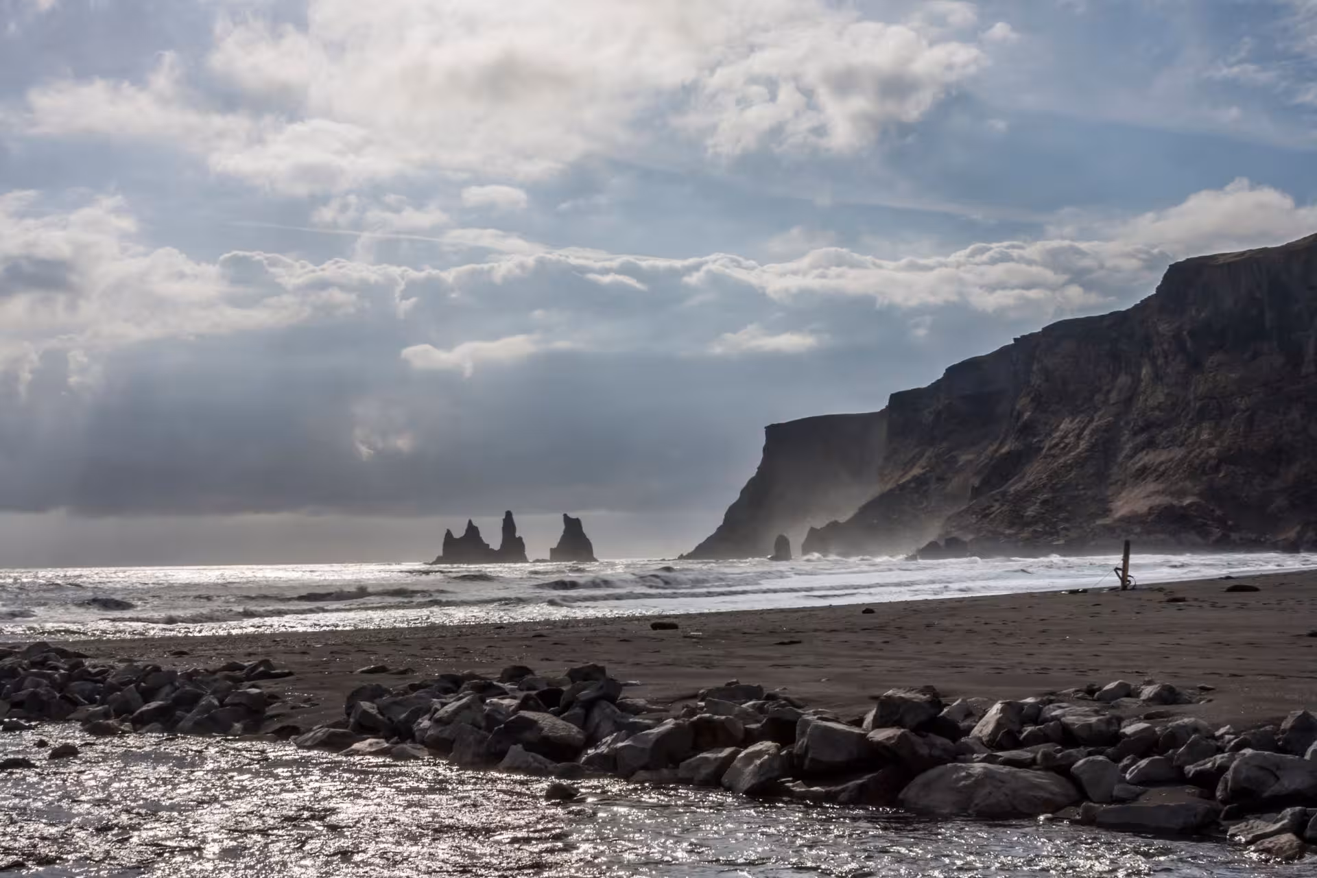 Black sand beach with volcanic rock sea stacks and dramatic cliffs on Iceland's south coast