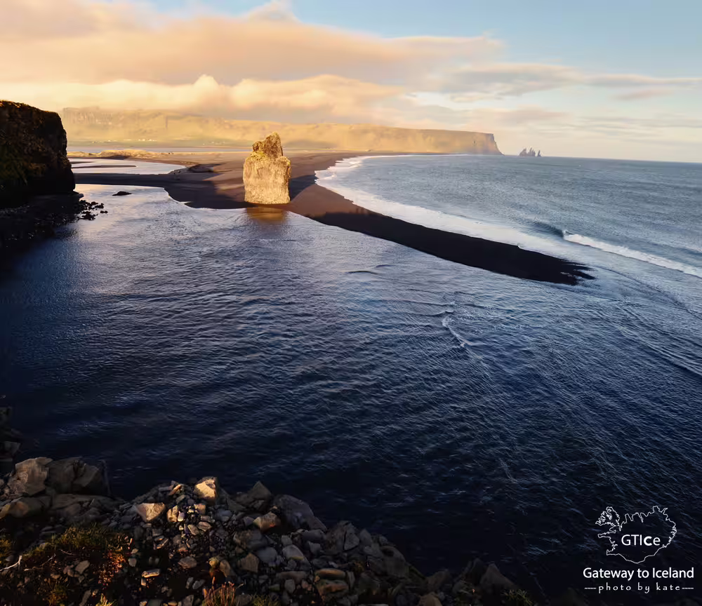 Black sand beach with sea stack and volcanic coastline on Iceland's south coast at golden hour