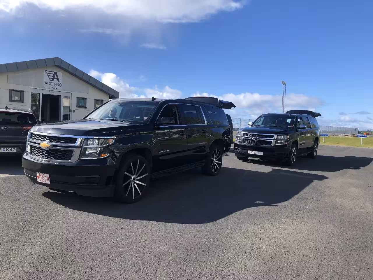 Two black Chevrolet Suburban SUVs parked at ACE FBO terminal in Westman Islands, Iceland