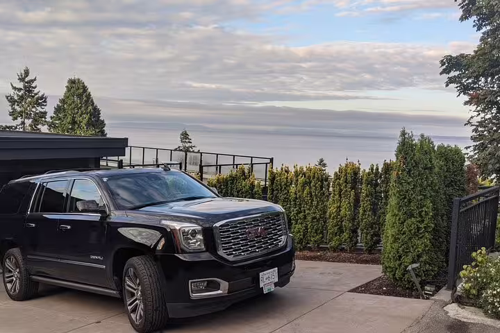 Black GMC Yukon Denali SUV parked in driveway for private airport transfer service