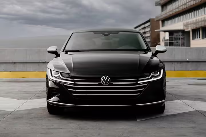 Black Volkswagen Arteon sedan front view for private transfer from Milan to Zurich