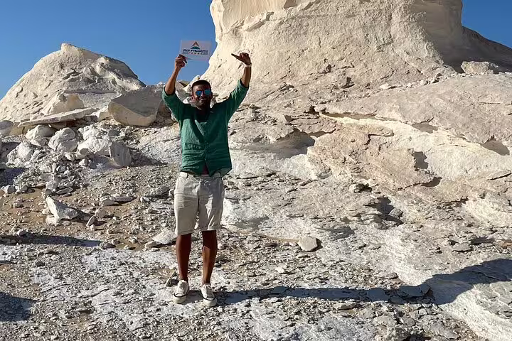 Traveler celebrating at chalk rock formations on Black & White Desert 2-day jeep safari tour with camp