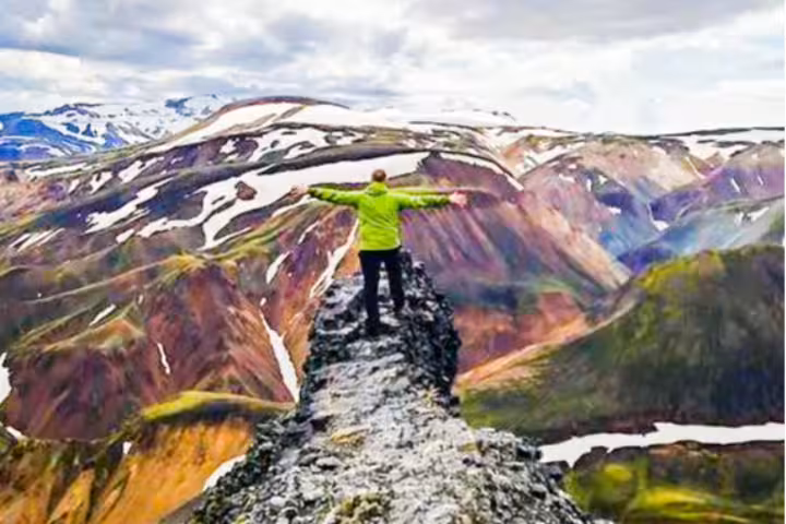 Standing on the edge of an obsidian cliff on top of Bláhnúkur in Landmannalaugar, Challenging hike but can be done in our day tour