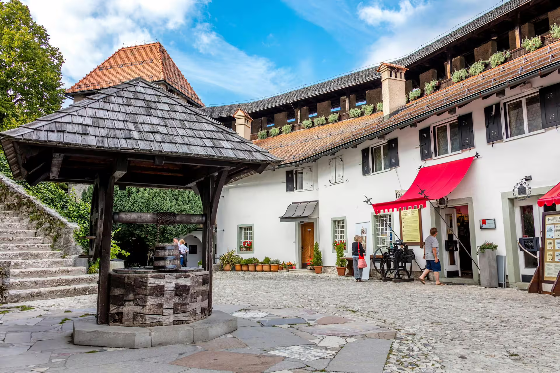 Bled Castle courtyard in summer, Slovenia, with historic well and museum entry on Lake Bled tour