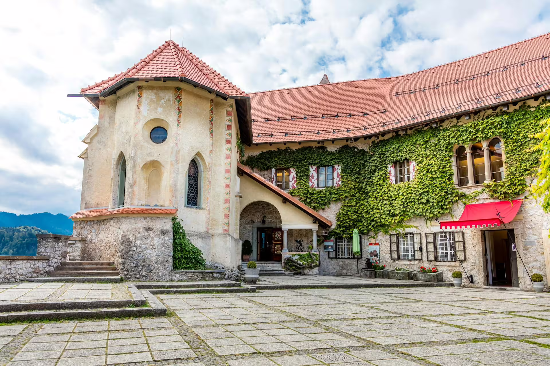 Bled Castle courtyard in summer, ivy-covered walls and red-tiled roof, stop on Lake Bled guided tour