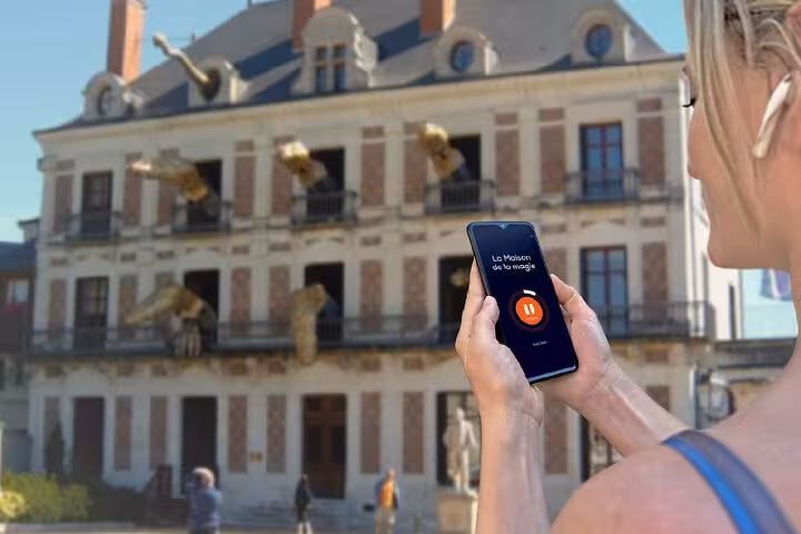 Tourist using audio guide app at La Maison de la Magie in Blois, France