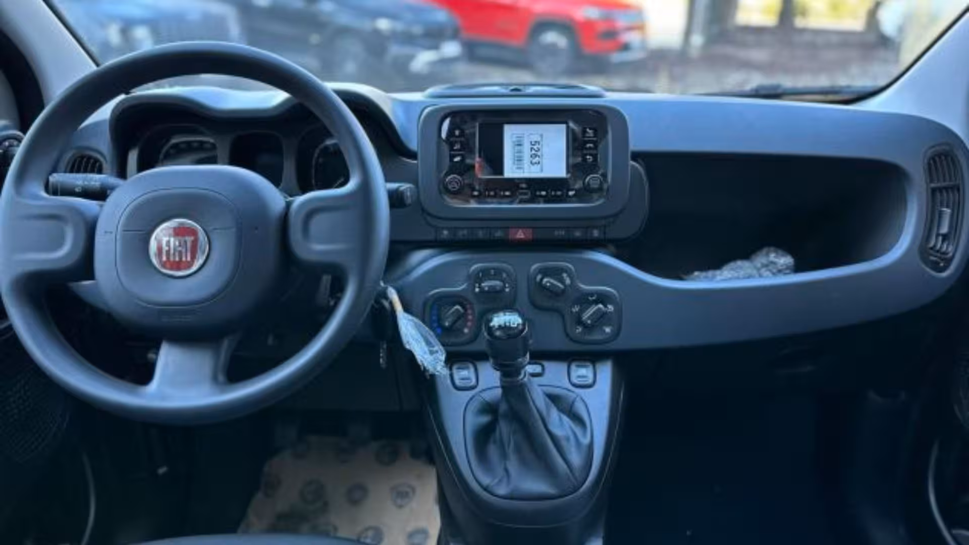 Interior of a blue car showcasing the dashboard and steering wheel, available for hire in Calasetta, Sardinia.