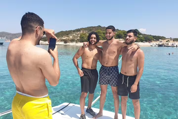 Friends posing on boat in crystal-clear sea during Scheduled Blue Cave & 5 Islands tour, Vis archipelago