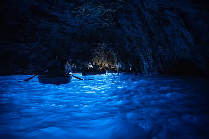 Enchanting boat tour inside the illuminated Blue Grotto cave, a highlight of the Naples iconic sights guided tour.