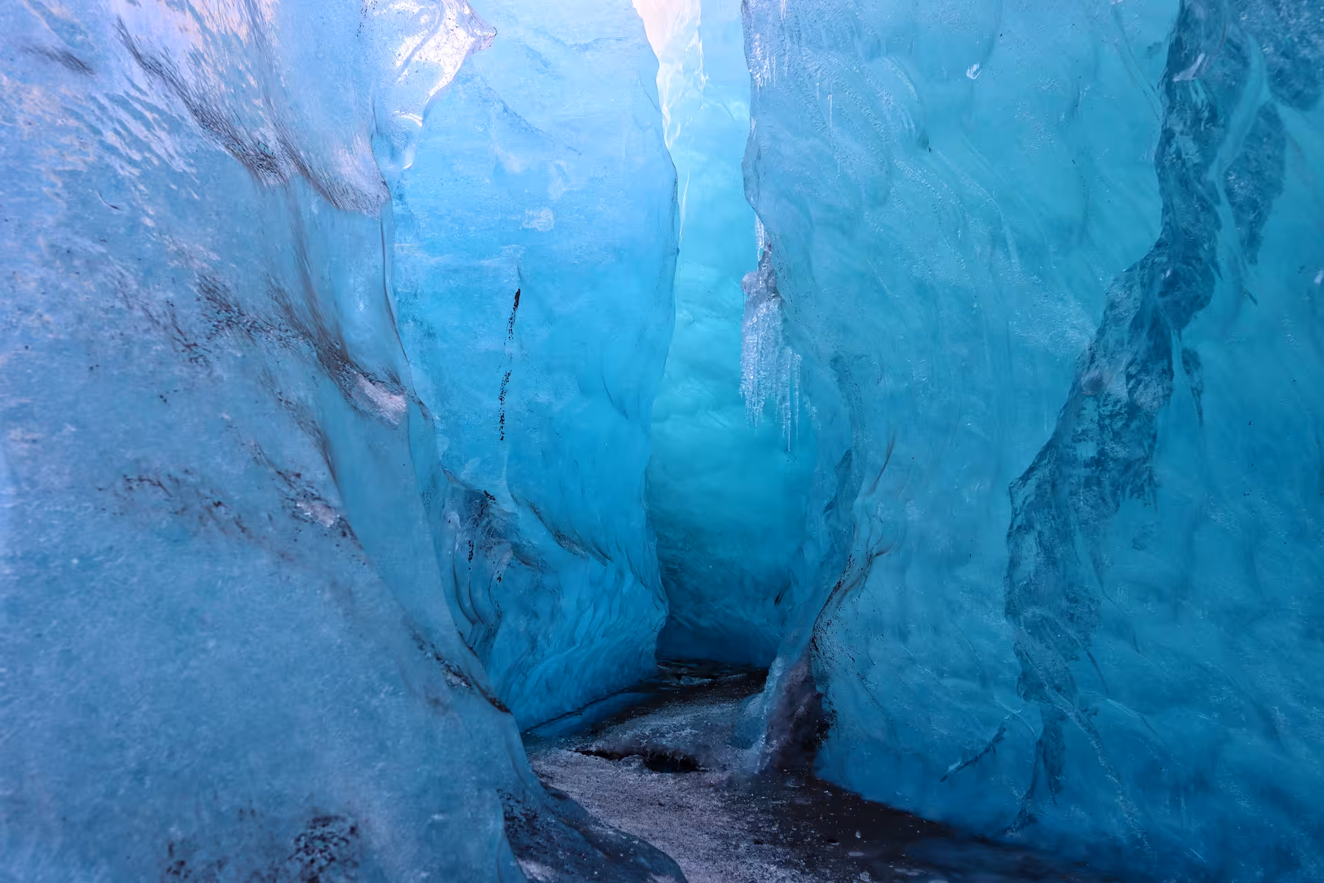 Narrow turquoise blue ice cave passage inside a glacier in Iceland