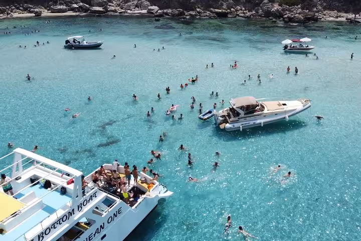 Blue Lagoon Akamas boat stop with swimmers in crystal-clear water on Paphos bus and boat tour