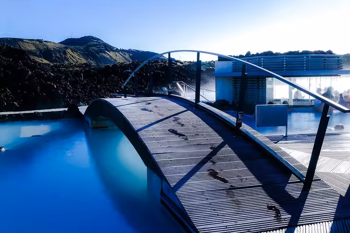 Wooden bridge over Blue Lagoon geothermal pool with volcanic landscape in Iceland