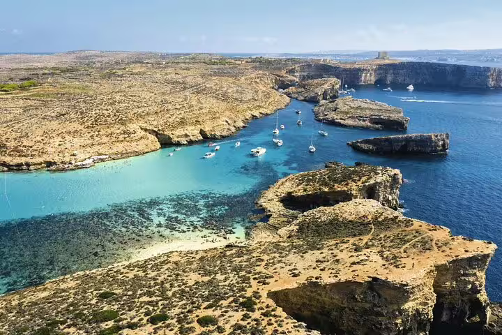 Aerial view of stunning Blue Lagoon Comino Malta with turquoise waters and boats on a full-day island boat tour