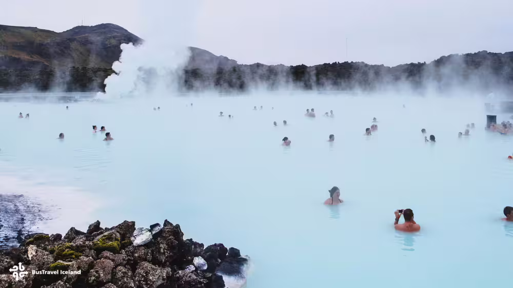Visitors bathing in the steaming milky-blue geothermal waters of the Blue Lagoon, Iceland