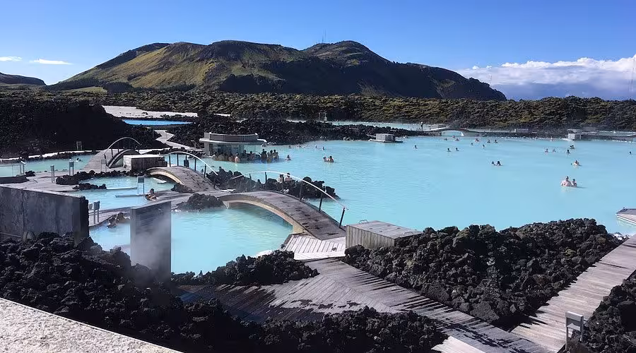 Blue Lagoon geothermal spa in Iceland with milky-blue water, lava rocks and walkways on Reykjavik to KEF transfer