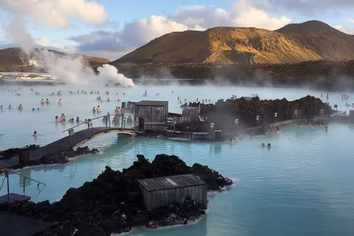 Blue Lagoon geothermal spa in Iceland with steaming milky-blue waters, lava rocks, and mountain backdrop