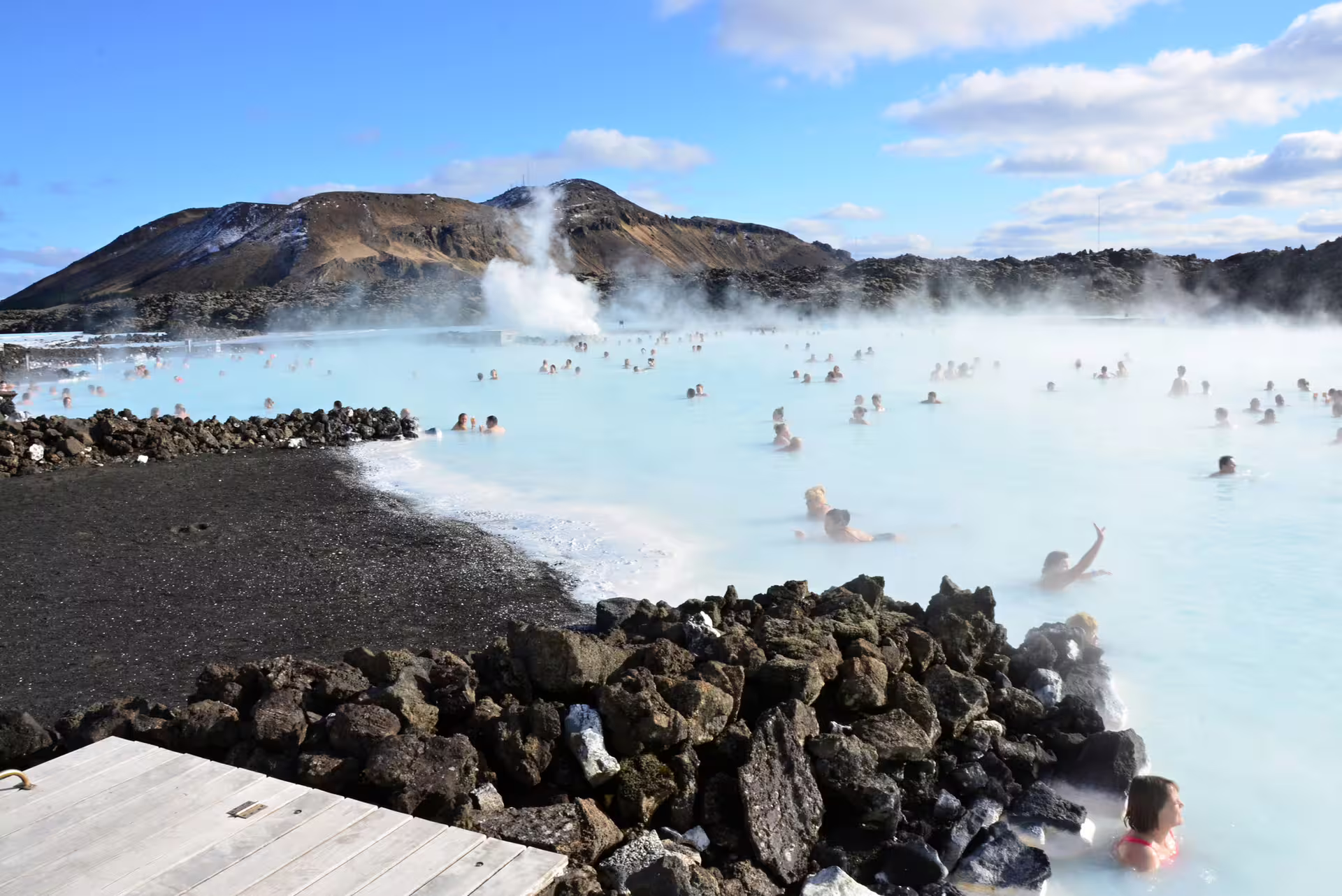 Aerial view of Blue Lagoon geothermal spa in Iceland with vivid turquoise waters and bathers at sunset