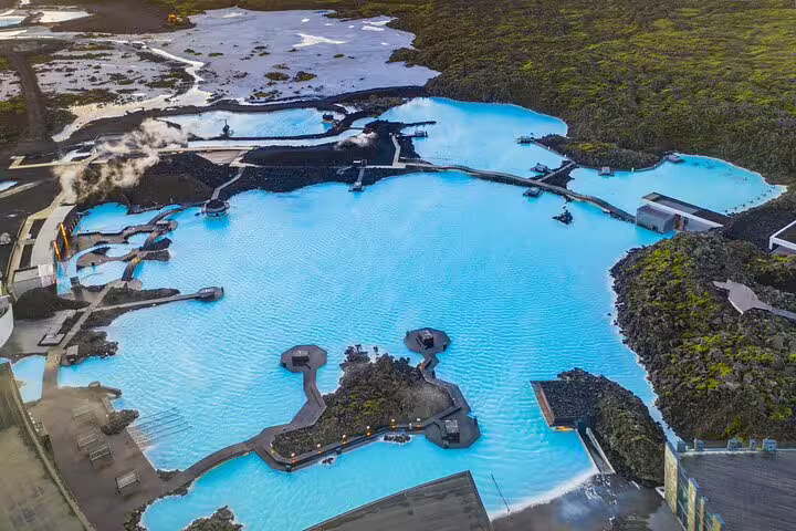 Aerial view of Blue Lagoon geothermal spa with vivid turquoise waters surrounded by black lava fields in Iceland