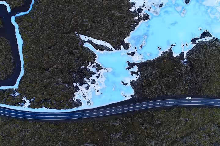 Aerial view of road winding through Blue Lagoon geothermal area with milky blue waters in Iceland