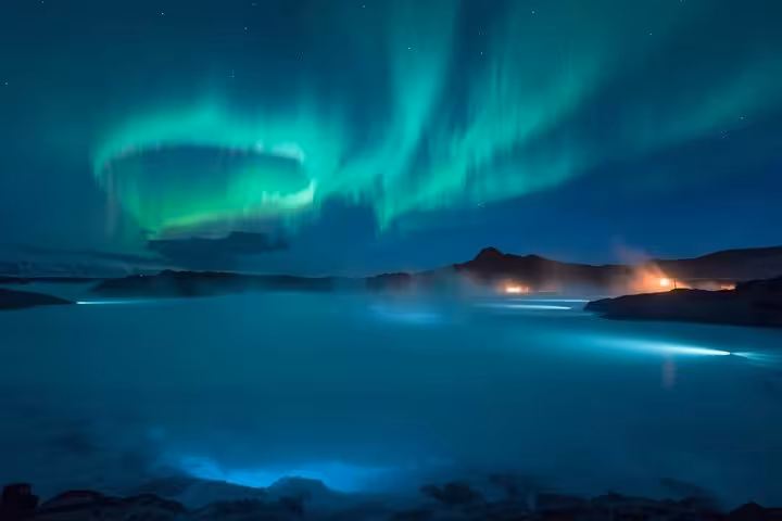 Aurora borealis glowing over the misty Blue Lagoon geothermal spa in Iceland at night