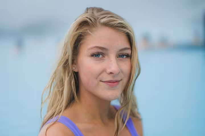 Young woman with blonde hair and blue eyes smiling near Blue Lagoon Iceland
