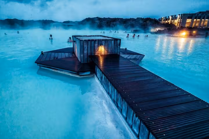 Steaming Blue Lagoon geothermal spa near Keflavik Airport with wooden boardwalk at dusk, Iceland