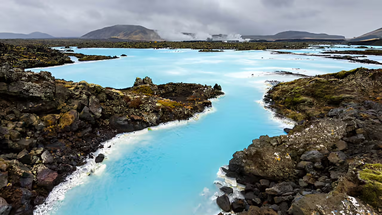 Milky blue geothermal waters of Blue Lagoon surrounded by dark lava rocks in Reykjanes, Iceland