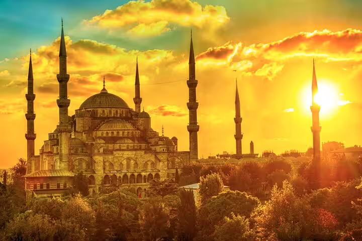 Sunset view of the majestic Blue Mosque in Istanbul, highlighting its iconic minarets and golden sky on guided tour.