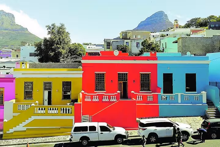 Vividly painted houses in Bo-Kaap with Table Mountain backdrop, highlighting Cape Town's iconic architecture.
