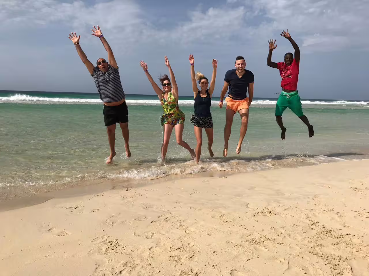 Travelers jumping in the shallows on Boa Vista wild beach, Cape Verde full-day island adventure