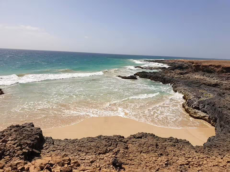 Rocky cove and turquoise surf on Boa Vista island wild beaches tour, Cape Verde coastal scenery