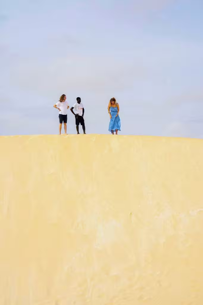 Visitors standing atop golden dunes in Viana Desert, Boa Vista Island, during a full-day wild beaches excursion